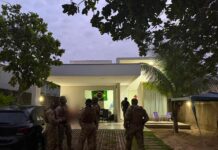 Policiais do Amazonas são presos por roubo de R$ 23 milhões em ouro após simularem apreensão em Roraima Policiais em trajes táticos no quintal de uma residência durante o cumprimento de mandados da operação que investiga o roubo de R$ 23 milhões em ouro.