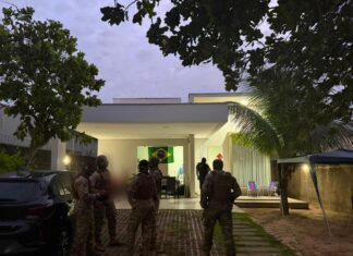 Policiais do Amazonas são presos por roubo de R$ 23 milhões em ouro após simularem apreensão em Roraima Policiais em trajes táticos no quintal de uma residência durante o cumprimento de mandados da operação que investiga o roubo de R$ 23 milhões em ouro.